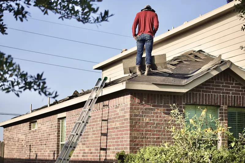 Professional roofer working on a residential roof in Hollingsworth Manor